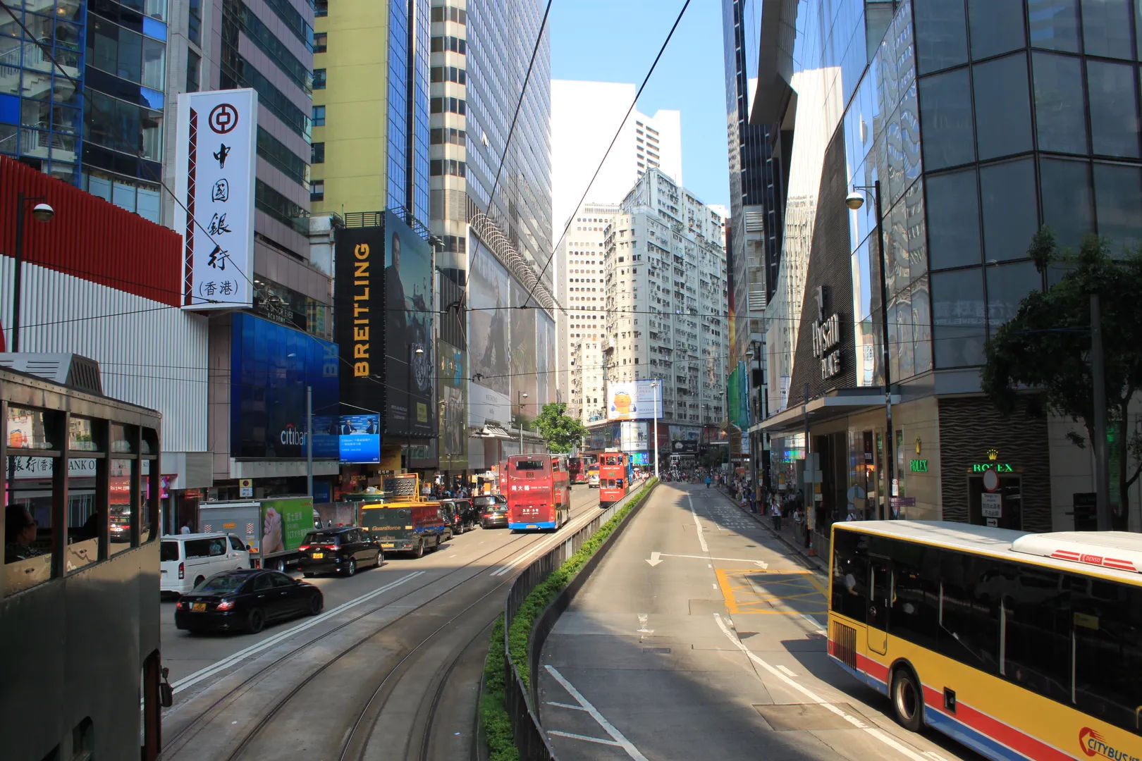Ruchliwa ulica w Hongkongu z tramwajami i drapaczami chmur