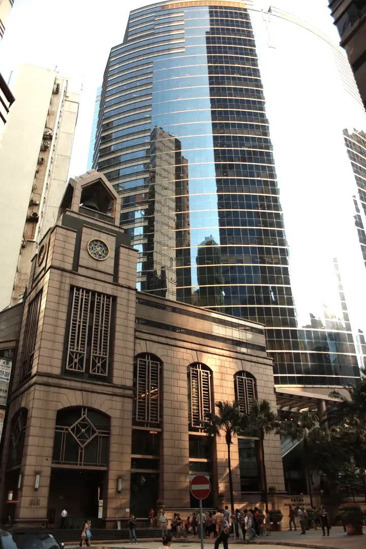 Zabytkowy zegar otoczony wysokimi wieżowcami w Hongkongu