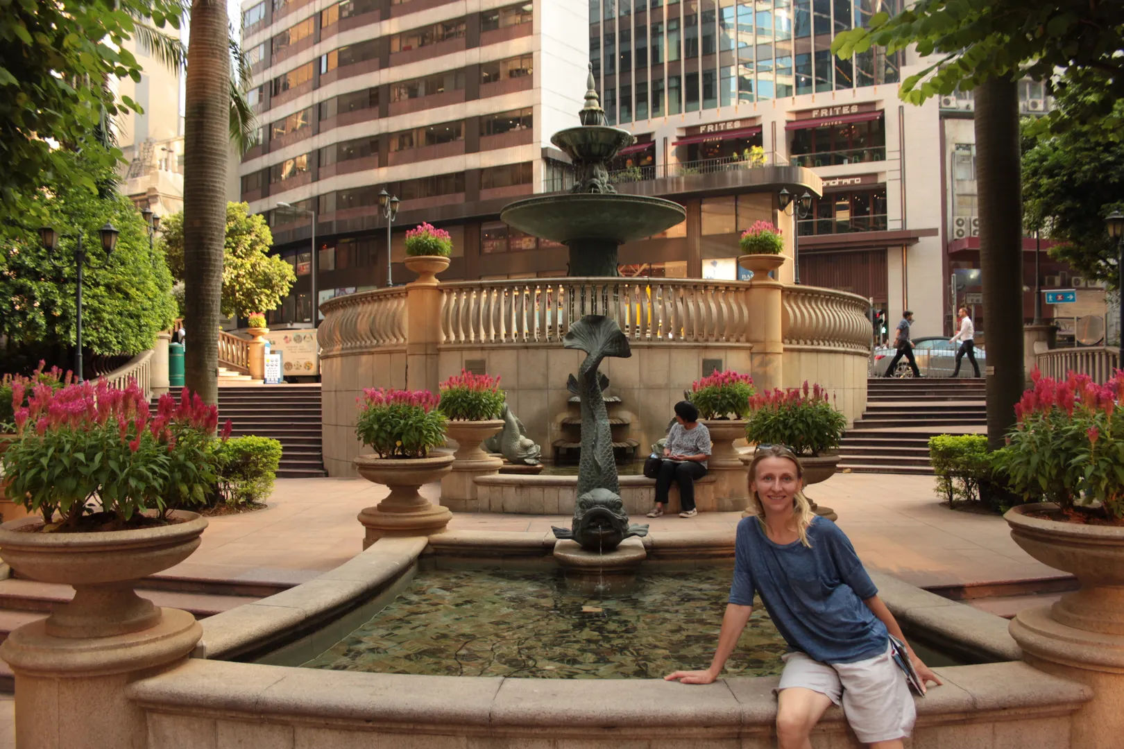Osoba siedząca przy fontannie w nowoczesnym centrum Hongkongu