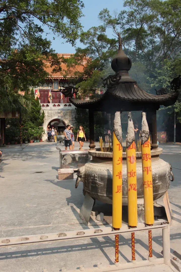 Zbliżenie na duże kadzidła palące się przed świątynią na Lantau