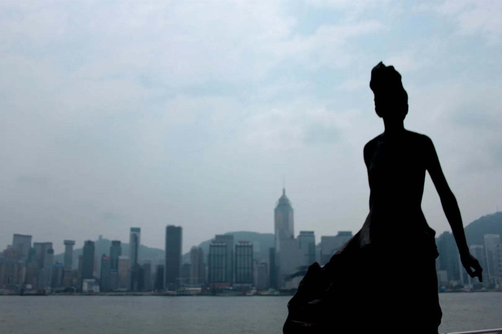 Posąg kobiety na tle panoramy miasta Hongkongu