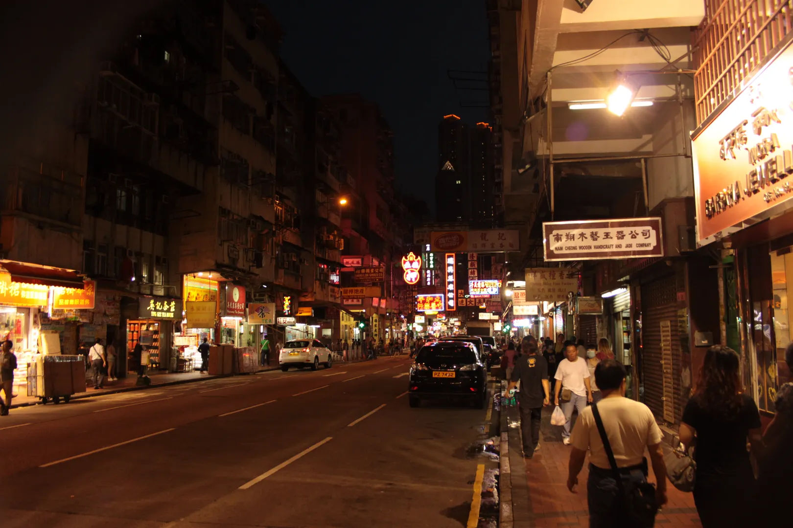 Zatłoczona ulica w nocy w Kowloon, Hongkong, z neonowymi znakami i spacerującymi ludźmi