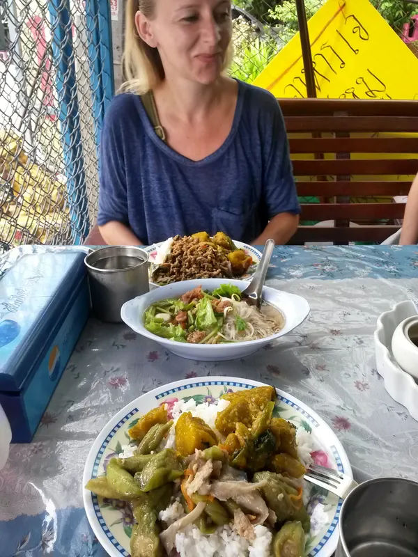 Talerz z tradycyjnym azjatyckim posiłkiem, składający się z makaronu, mięsa i warzyw.