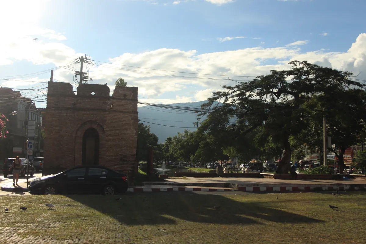 Tradycyjna ulica z wąską drogą w Chiang Mai, pełna tuk-tuków i lokalnych sklepów.