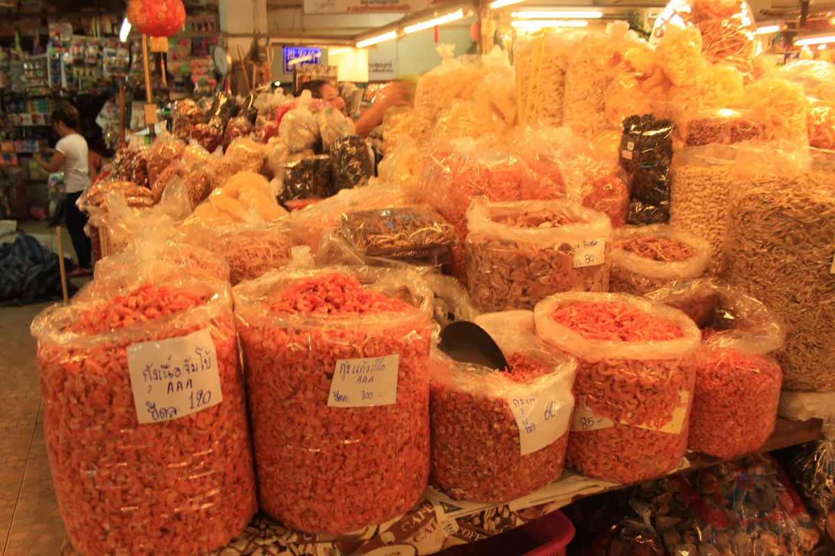 Targ w Chiang Mai z różnorodnymi suszonymi owocami i przyprawami w plastikowych workach.