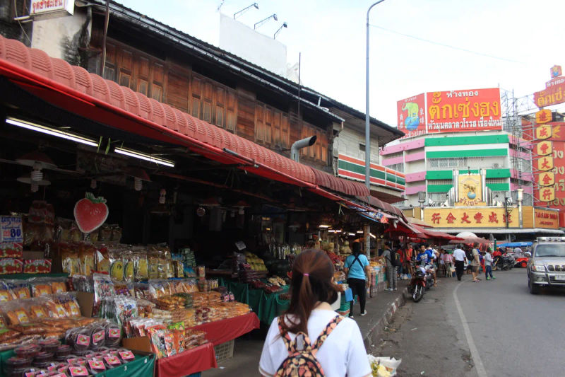 Widok na tradycyjny rynek w Chiang Mai, pełen straganów z produktami spożywczymi.
