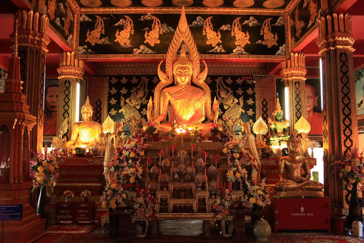 Zbliżenie na złoty posąg Buddy w świątyni Wat Phan On w Chiang Mai.