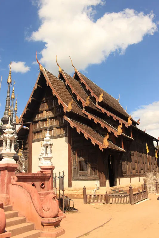 Drewniana świątynia Wat Phan Tao w Chiang Mai z dekoracyjnymi dachami.
