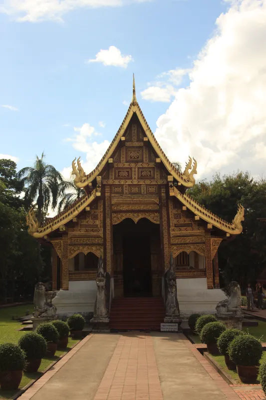 Złocona fasada świątyni Wat Phra Singh w Chiang Mai, ozdobiona tradycyjnymi tajskimi ornamentami.