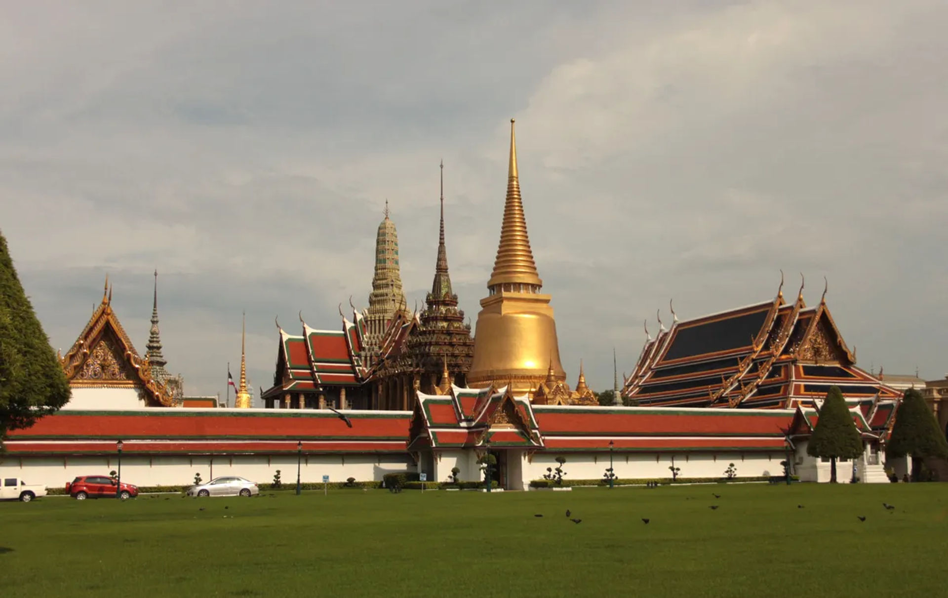 Widok na kompleks świątynny w Wat Phra Kaew w Bangkoku z złotą stupą i tradycyjną tajską architekturą
