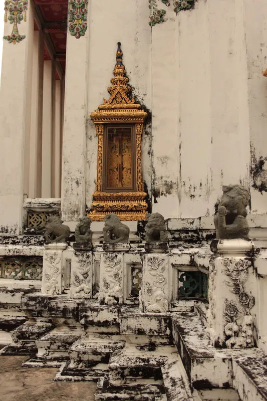 Zbliżenie na kamienne posągi w Wat Pho, Bangkoku, przedstawiające mistyczne postacie.