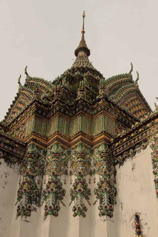 Widok na pagodę w Wat Pho w Bangkoku, z misternymi detalami ceramicznymi.