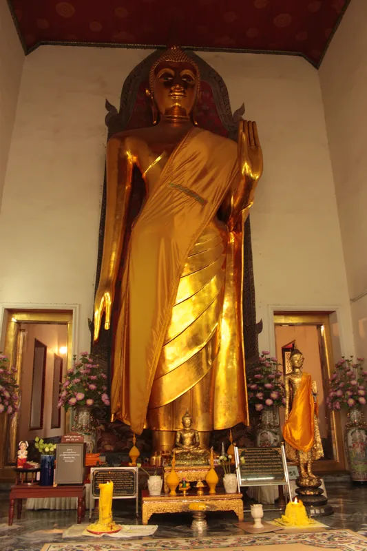 Posąg Buddy w Wat Pho w Bangkoku z pięknymi detalami wokół.