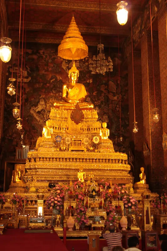 Złocisty posąg Buddy w Wat Pho, Bangkok, otoczony bogatymi dekoracjami.