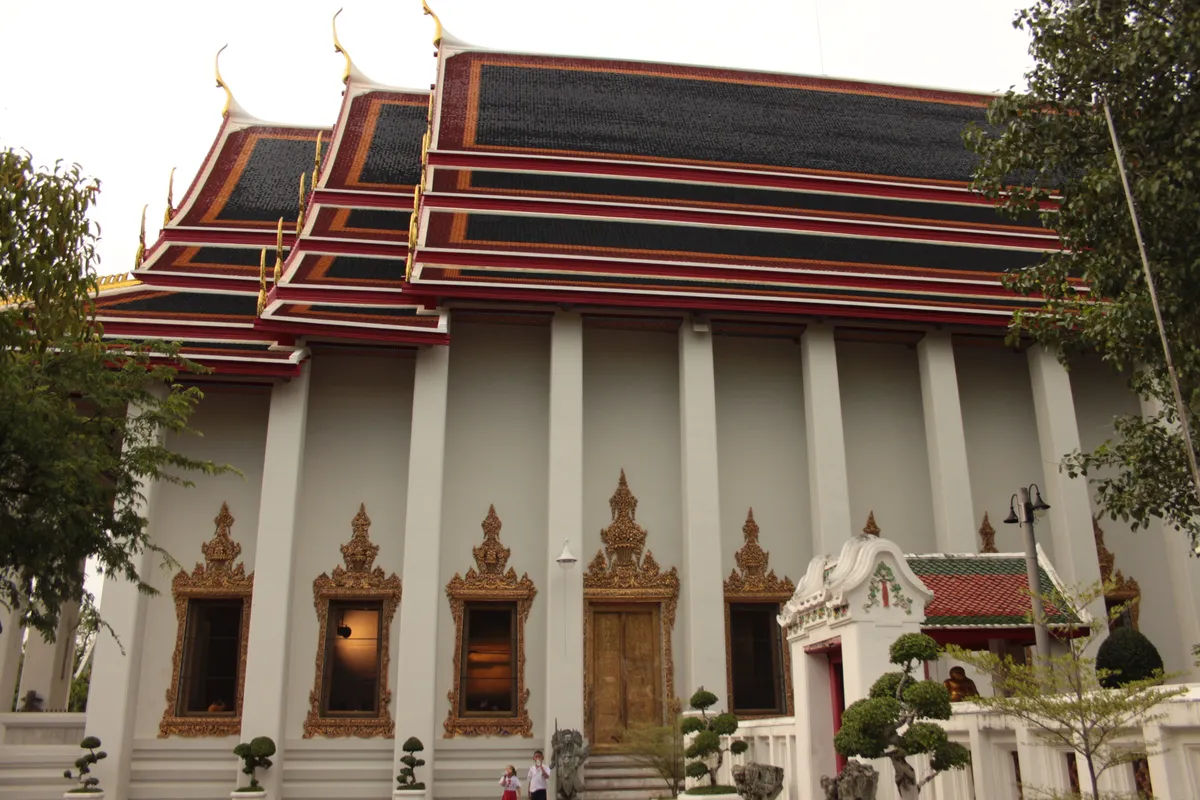 Zewnętrzna część Wat Pho z tradycyjną tajską architekturą i misternymi detalami.
