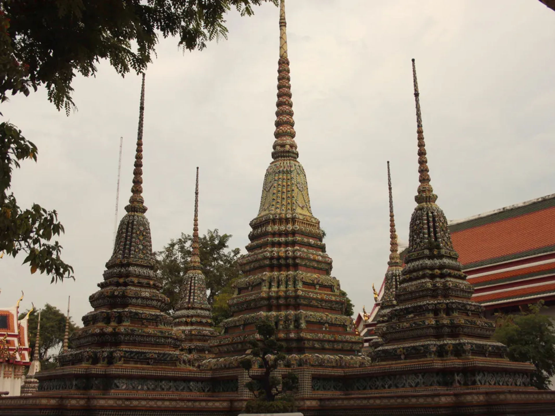 Szpiczaste stupy na tle tradycyjnej tajskiej architektury świątynnej w Bangkoku