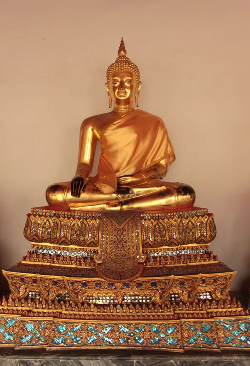 Zbliżenie na posąg Buddy w Wat Pho, z misternymi wzorami i złotymi dekoracjami.