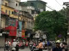 Ruch uliczny w Starej Dzielnicy Hanoi, z motocyklistami i budynkami o kolonialnej architekturze w tle