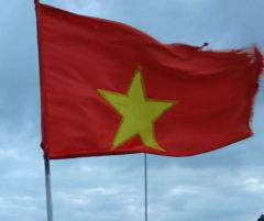 Czerwona flaga z żółtą gwiazdą, symbol Wietnamu, powiewająca na wietrze w Hanoi.