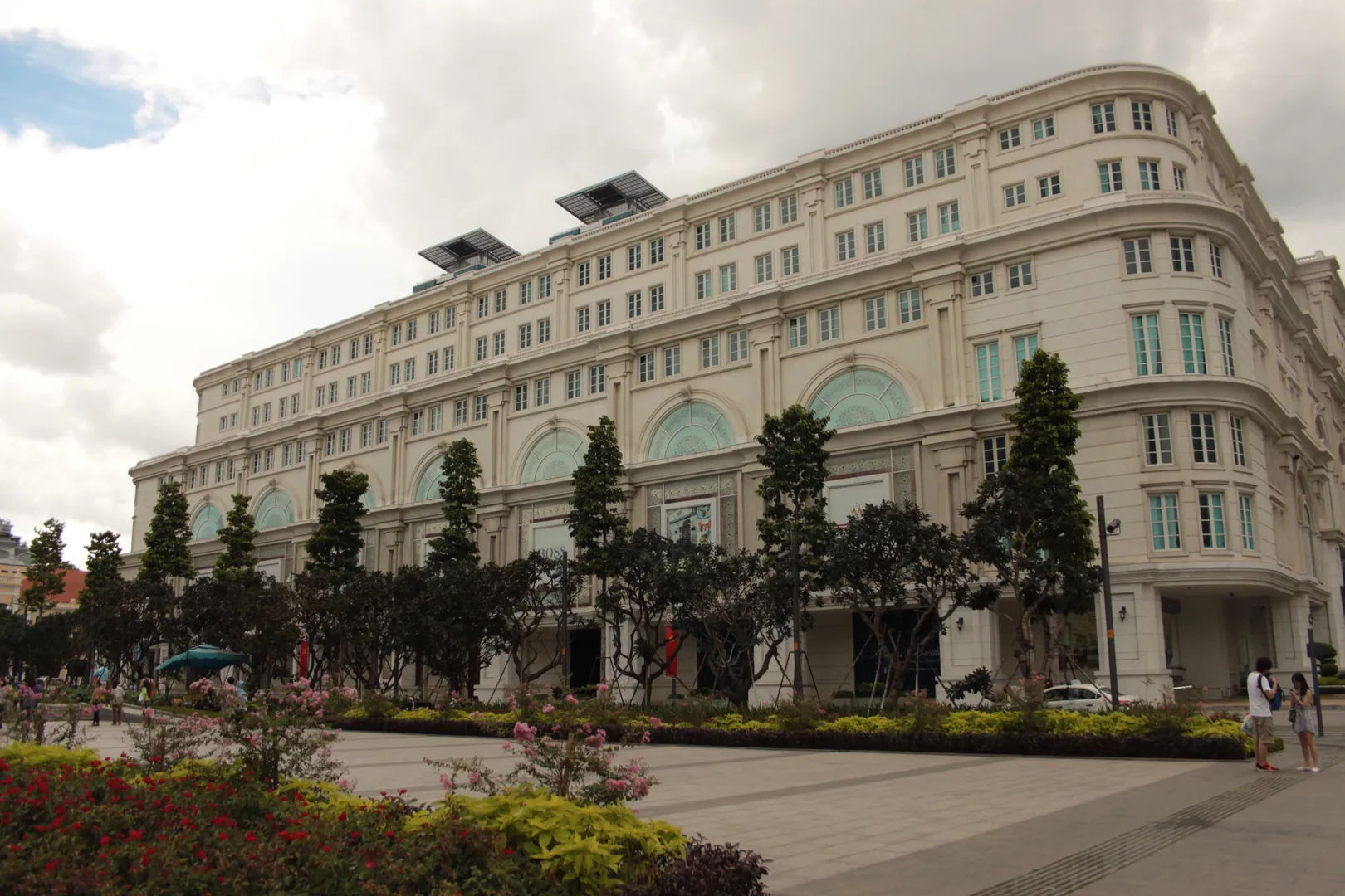 Luksusowy budynek hotelu Majestic w Sajgonie, Wietnam, z kwitnącymi ogrodami na pierwszym planie.