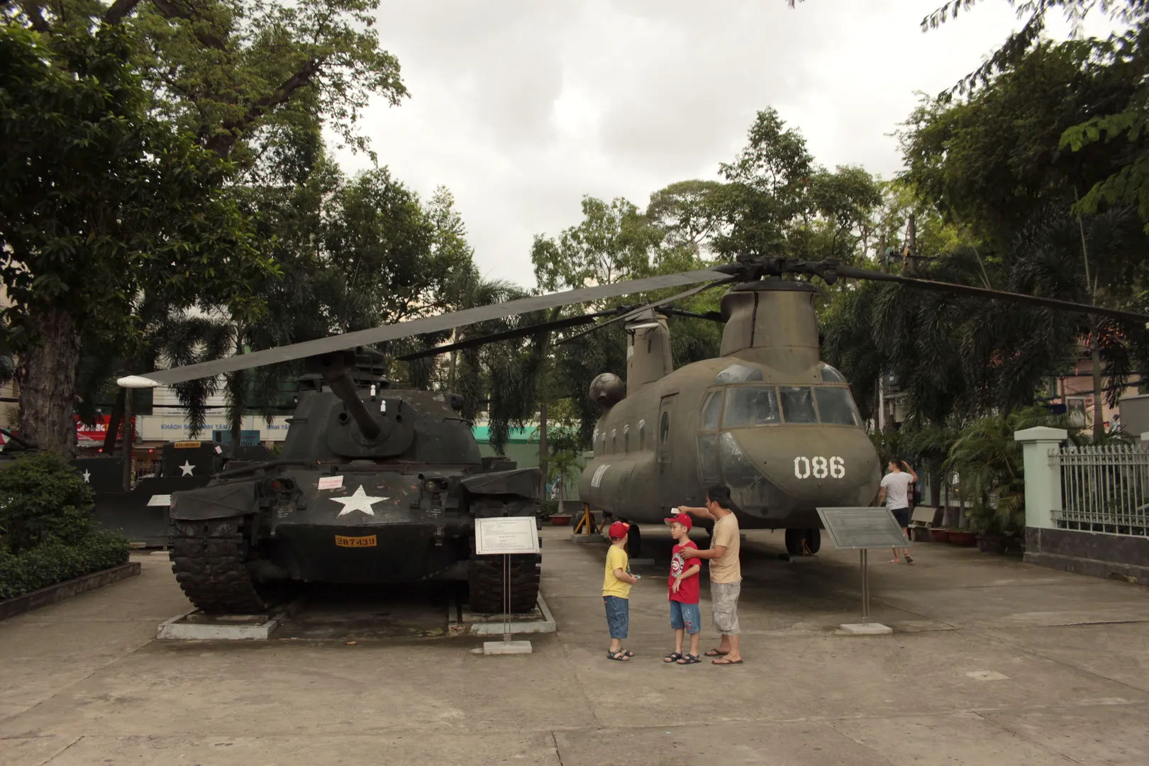 Dzieci z ojcem przy czolgu i helikopterze