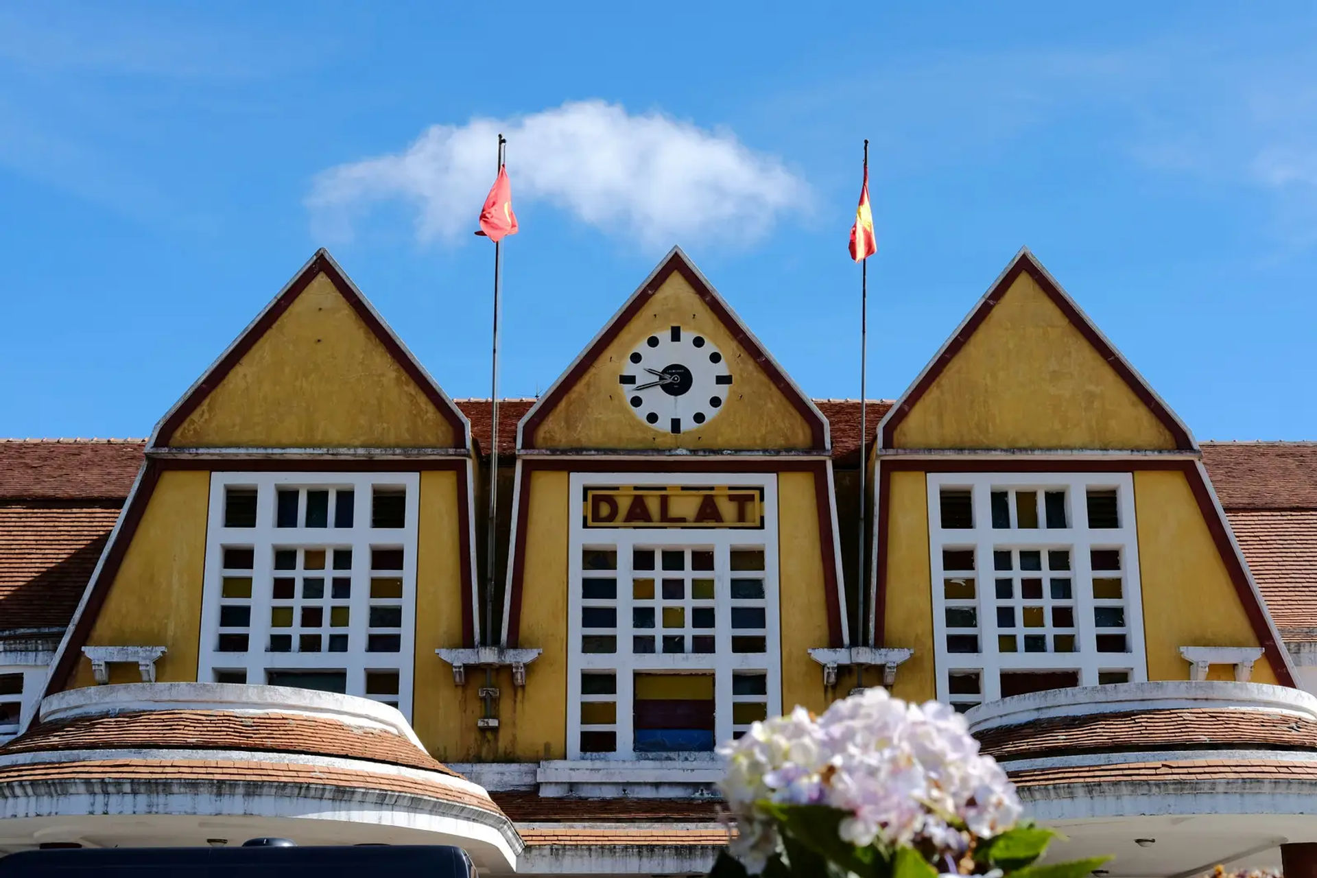 Kamiennice w kolonialnym stylu w otoczeniu parku i straganow, Dalat