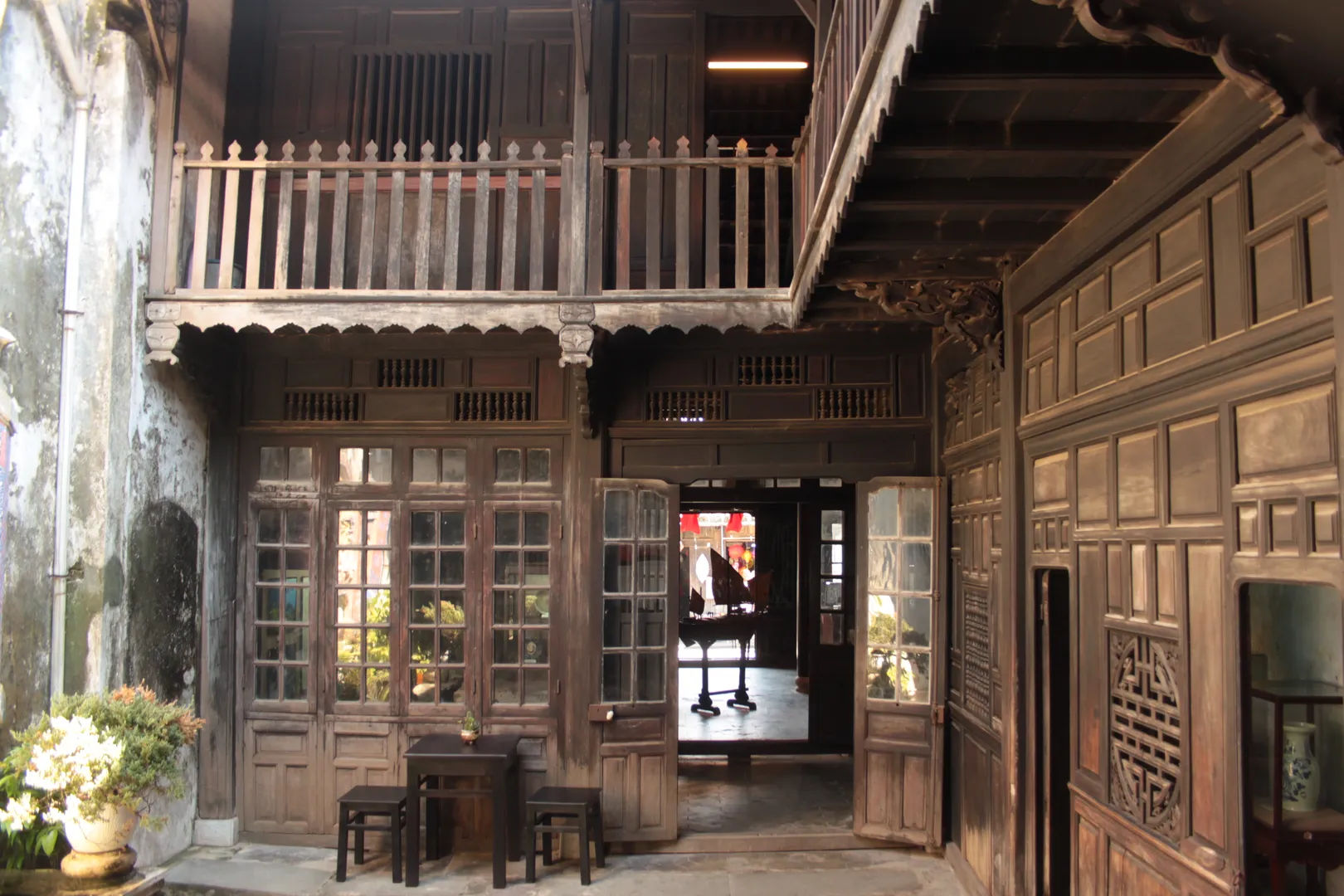 Dziedziniec tradycyjnego domu Tấn Ký w Hoi An, z drewnianymi detalami architektonicznymi i ozdobnymi elementami.