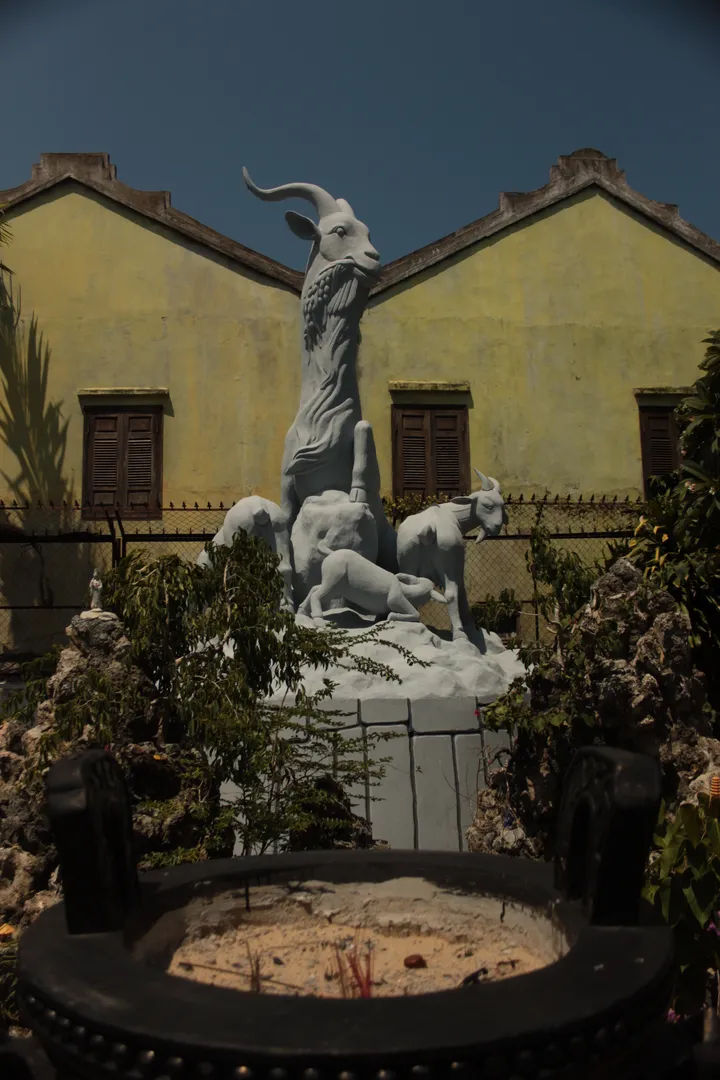 Kamienna rzeźba z białego marmuru przedstawiająca mitologiczną postać przed budynkiem w Hoi An, Wietnam.