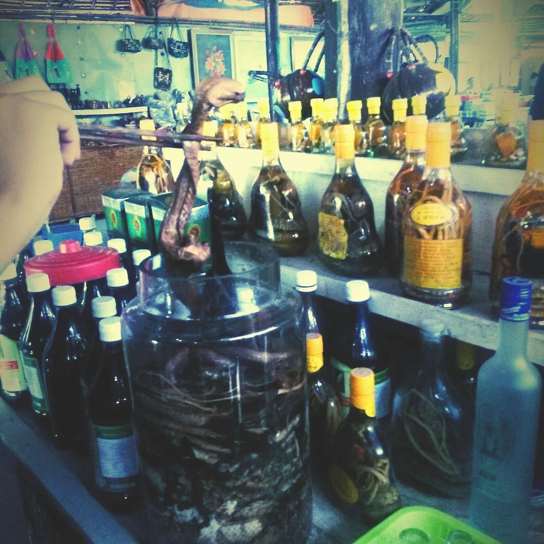Butelki z nalewkami i lokalnymi alkoholami na targu w Mekongu, Wietnam.