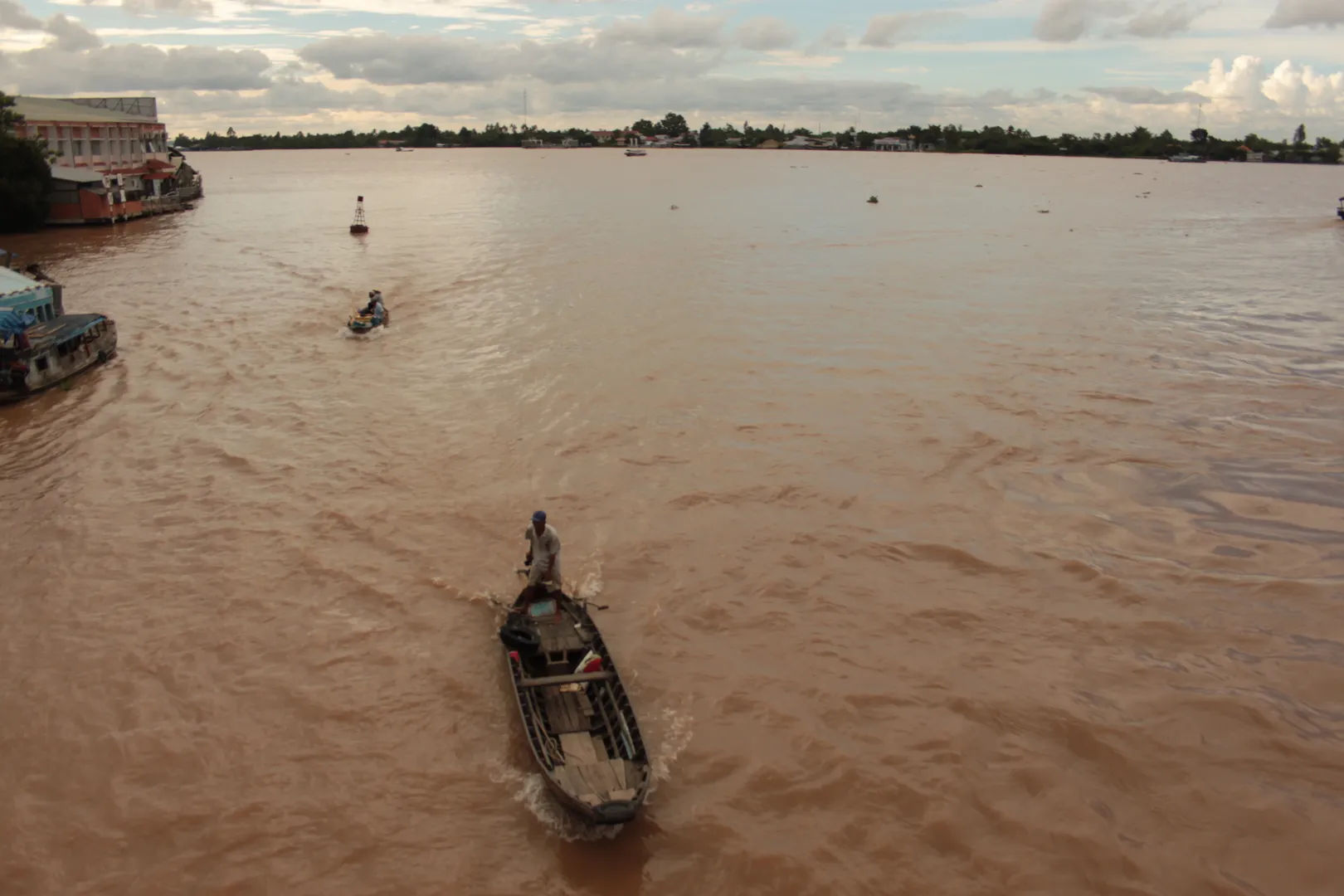Sampan płynący przez zielone kanały otoczone bujną roślinnością w delcie Mekongu