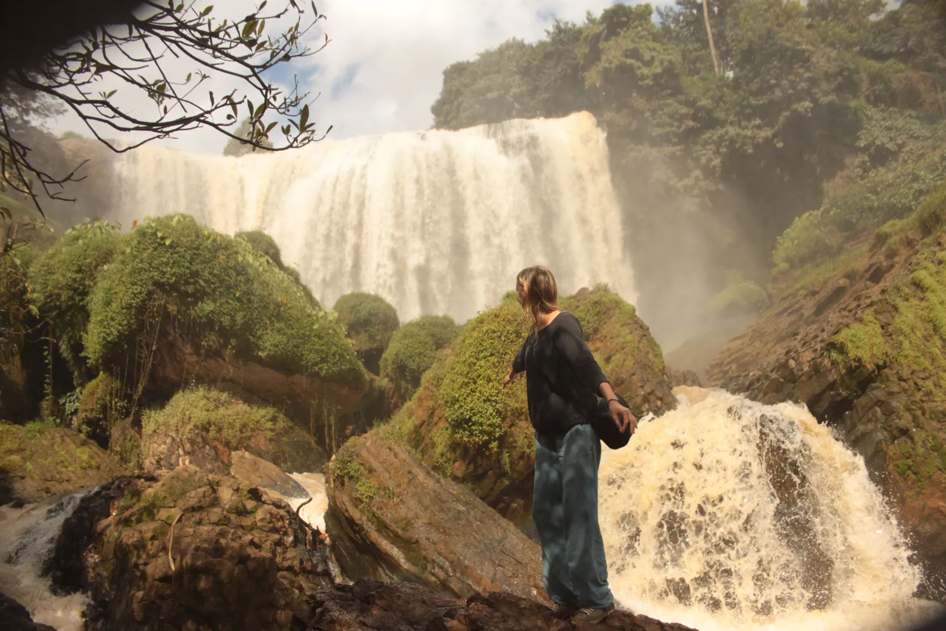 Kobieta stojąca bokiem do wodospadu Sloni, Dalat
