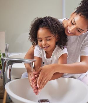 Mother and daughter washing hands.