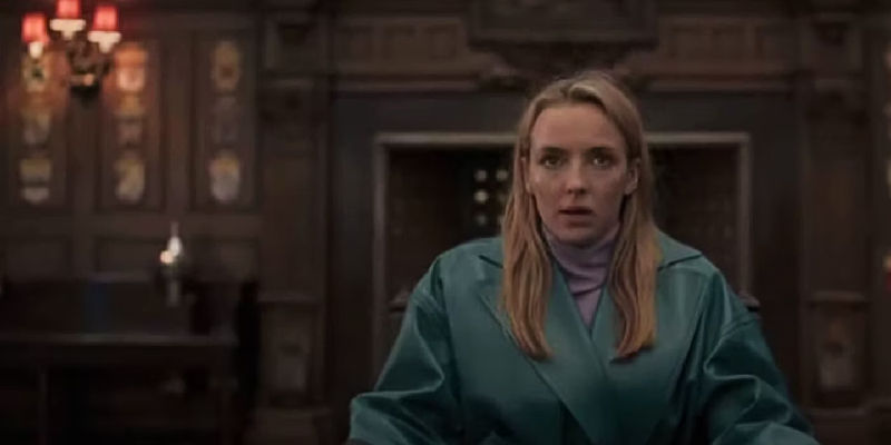 Jodie Comer as Villanelle sitting in a room in Killing Eve