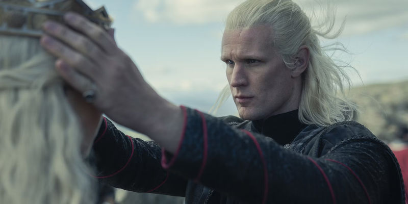 Matt Smith as Daemon placing a crown on Rhaenyra's head in House of the Dragon