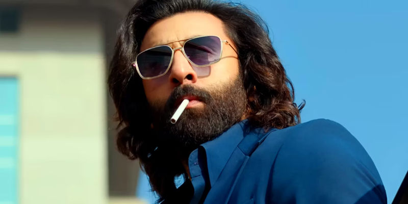 A Man with Long Hair Smoking a Cigarette in Animal