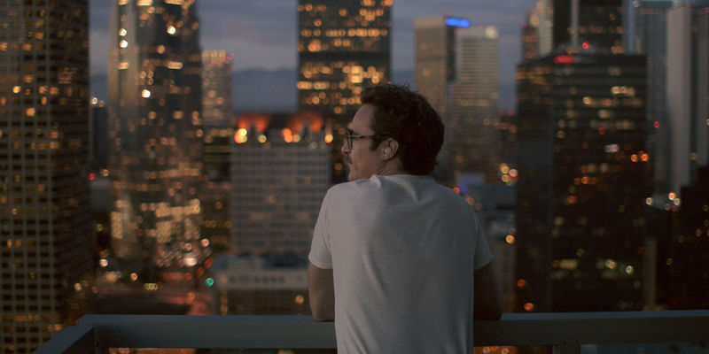 Joaquin Phoenix looking out at the city in Her