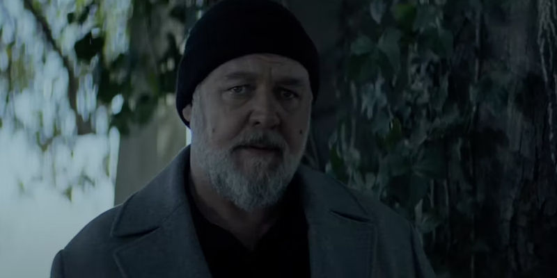 Russell Crowe standing by a tree as Roy in Sleeping Dogs