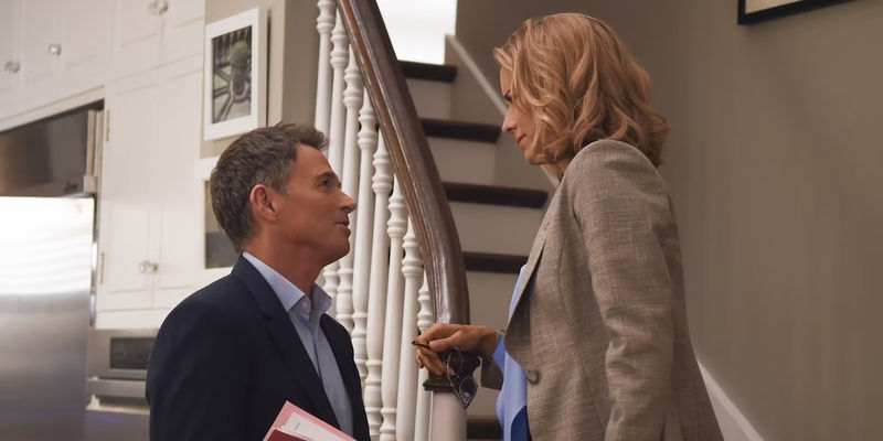Tim Daly stands below while Tea Leoni stands on the stairs in Madame Secretary