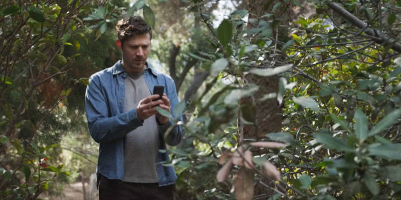 Elias Voit looking at his cell in the middle of the woods in Criminal Minds_ Evolution