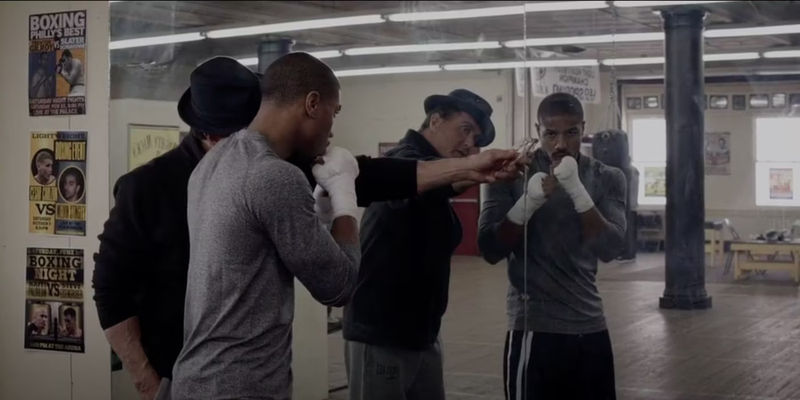 Sylvester Stallone and Michael B Jordan as Rocky and Creed looking in a mirror in Creed