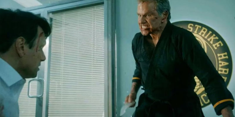 Martin Kove looking angry as John Kreese as he goes to attack Ralph Macchio's Daniel LaRusso in Cobra Kai
