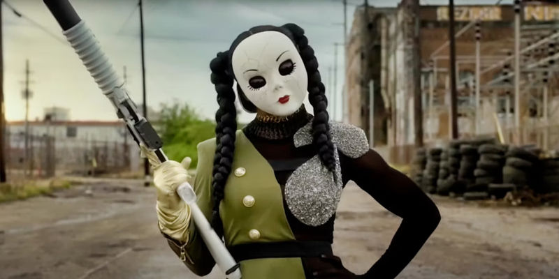 Dollface holds up a weapon while putting her hand on her hip in Twisted Metal.