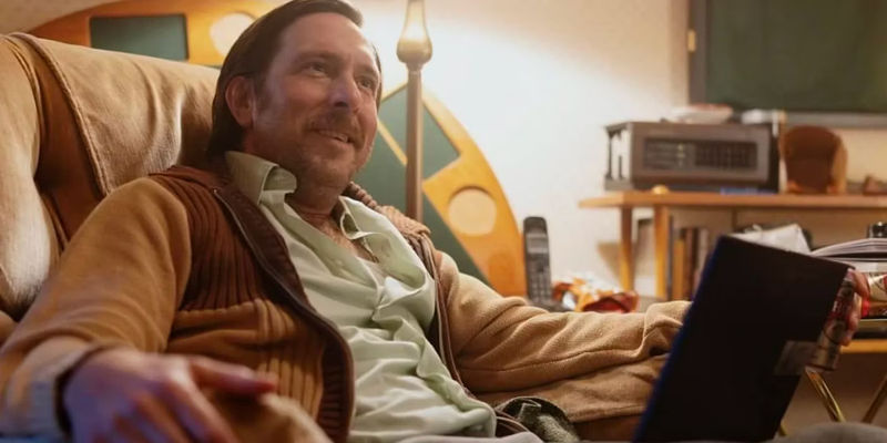 Timm Sharp as Gabe Ugliano sitting on a chair in the Percy Jackson TV show