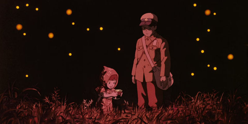 Seita and Setsuko surrounded by fireflies during the night in Grave of the Fireflies.