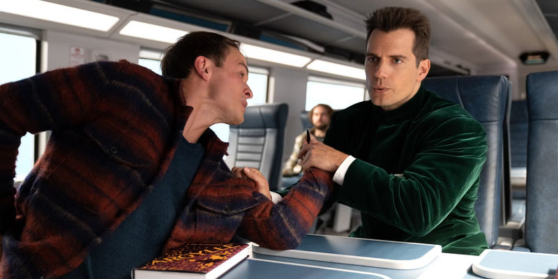 Agent Argylle smoothly grabs an assailant's hand on a train in Argylle