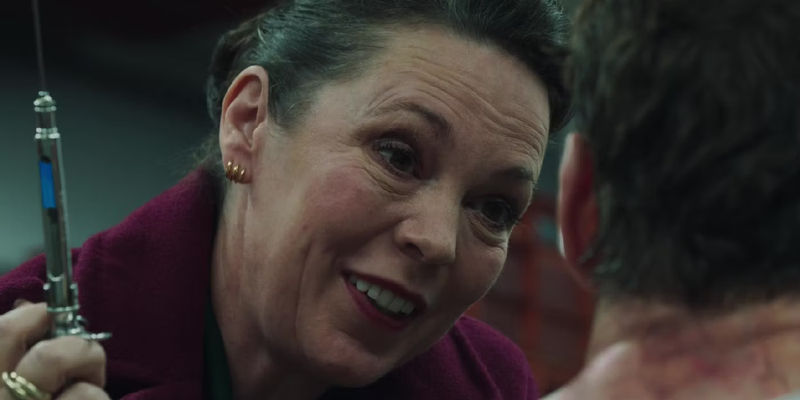 Olivia Colman as Sonya Falsworth smiling and holding a needle while interrogating a Skrull prisoner in Secret Invasion Season 1 Episode 2