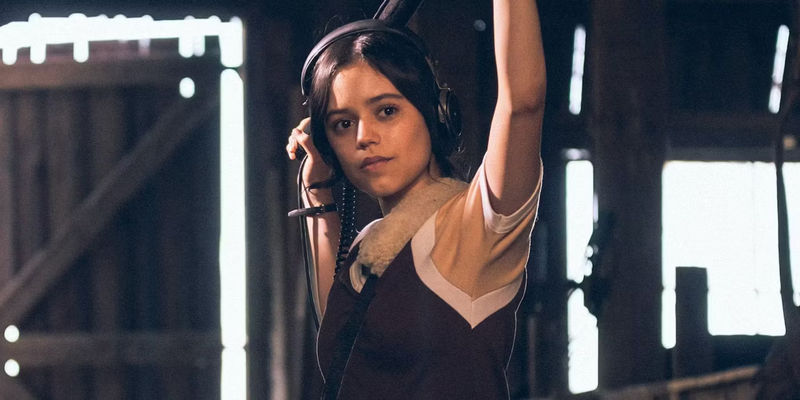 Jenna Ortega as Lorraine hold a boom mic in a scene from X.