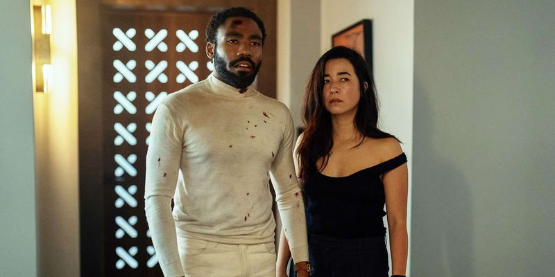 Donald Glover and Maya Erskine looking stunned in Mr. & Mrs. Smith tv series