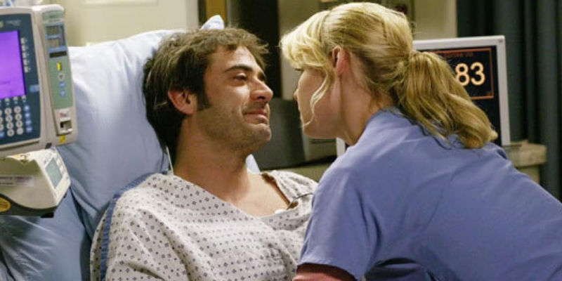 Izzie in bed with her patient, Denny.