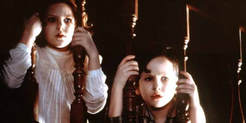 Anne and Nicholas Stewart staring out from the stair banister in The Others